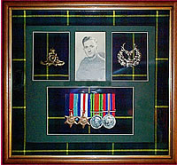Framed medal display including photograph, medals and badges
